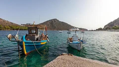 Traditional Greek fishing boats in Tolo with Romvi as the background
