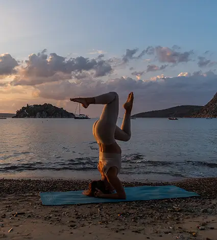 Woman doing on Tolo beach with the islands of Koronisi in the backgorund