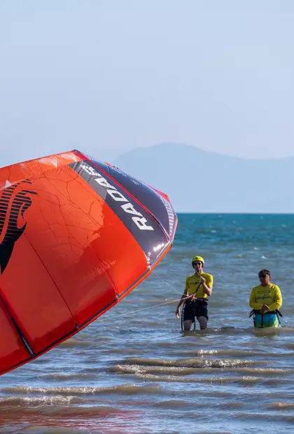 Man surfing on water holding a kite
