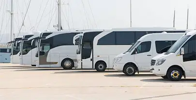 Different white vehicles parked in front of the other, photo taken from the side